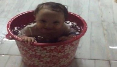 Sıcaktan bunalan bebek su dolu kovada serinledi