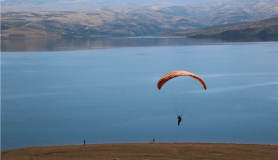 Baraj manzarası eşliğinde yamaç paraşütü keyfi