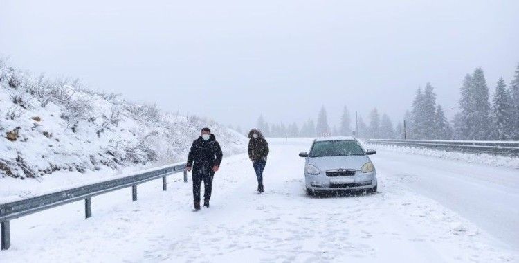 Kar yağışı nedeniyle yolda kalan araçlarını iterek çıkarmaya çalıştılar